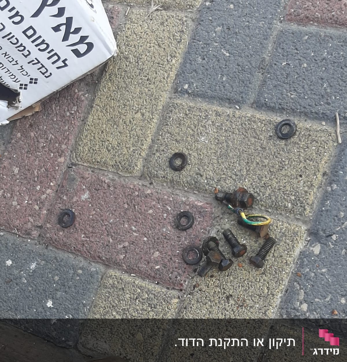 ברגים וחלקים חלודים על מדרכה